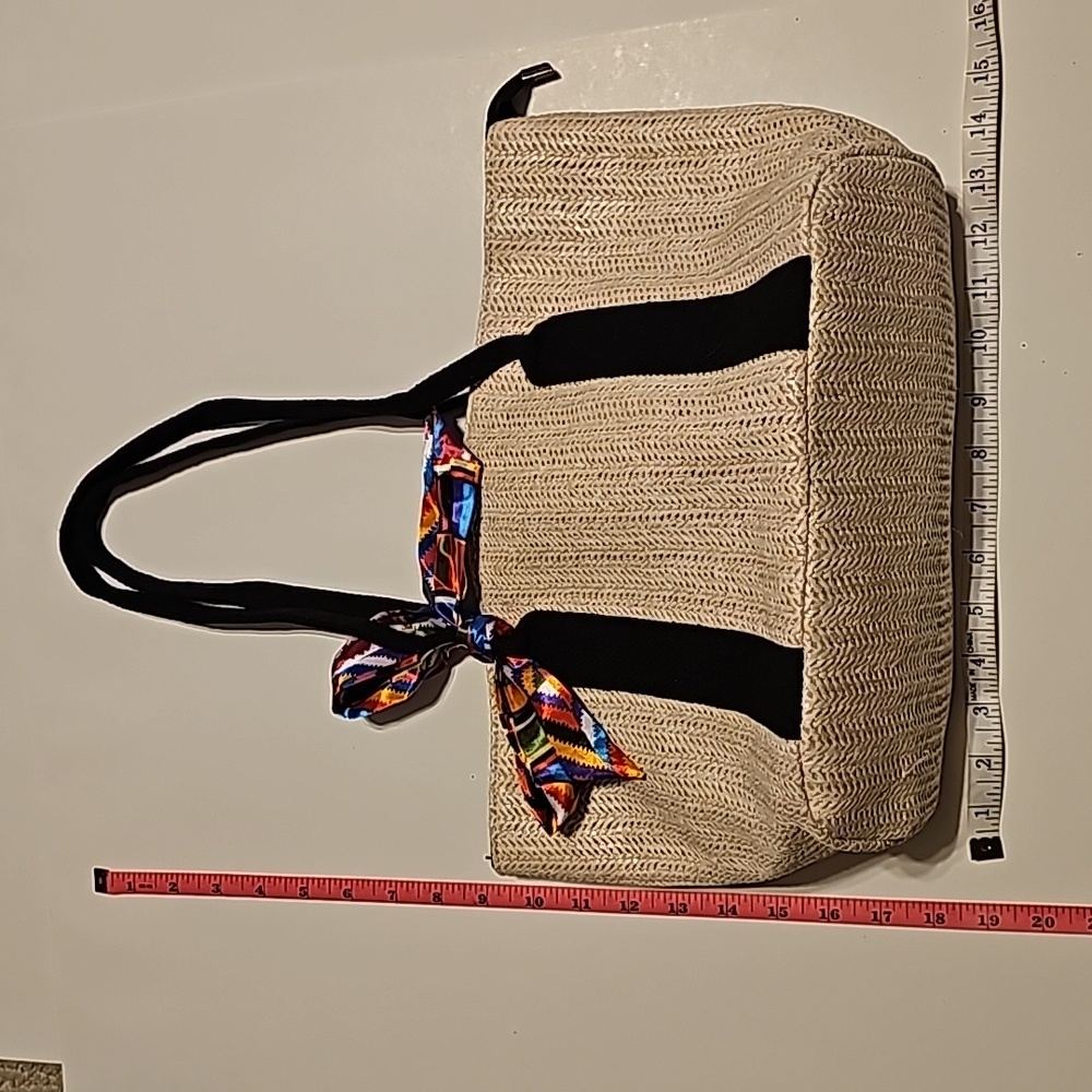 Unbranded straw purse with multi colored scarf tie accent.